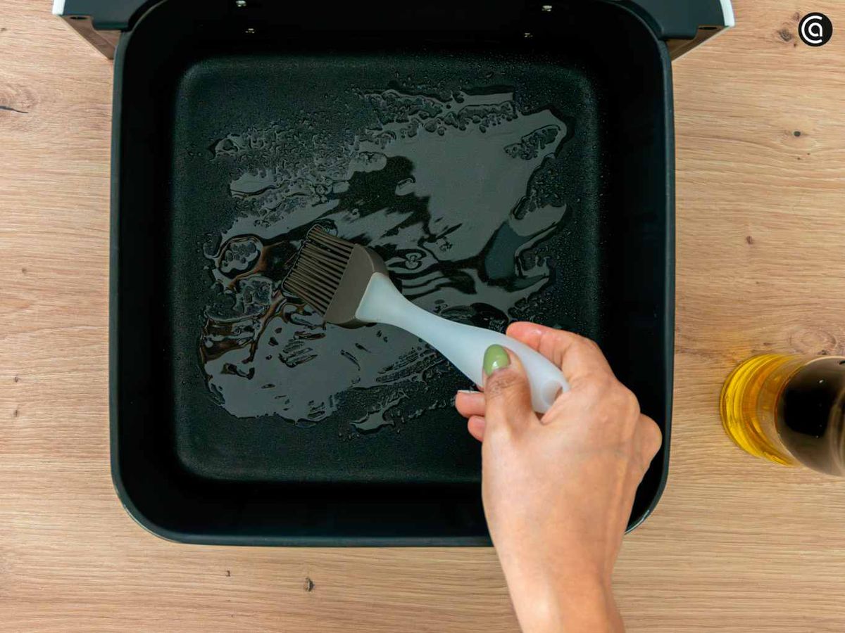 Rocía aceite en la cesta de la freidora de aire