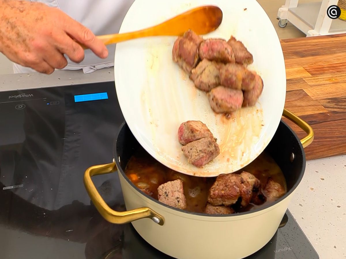 Añade los clavos de olor junto con vino, caldo y carne