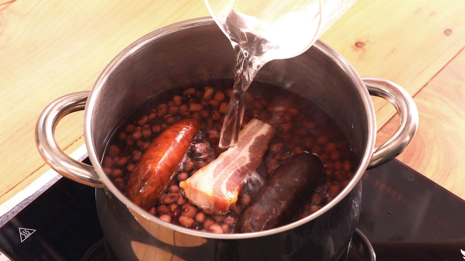Agrega las alubias, el tocino, el chorizo y la morcilla a una cazuela Alubias rojas con morcilla y chorizo paso 2