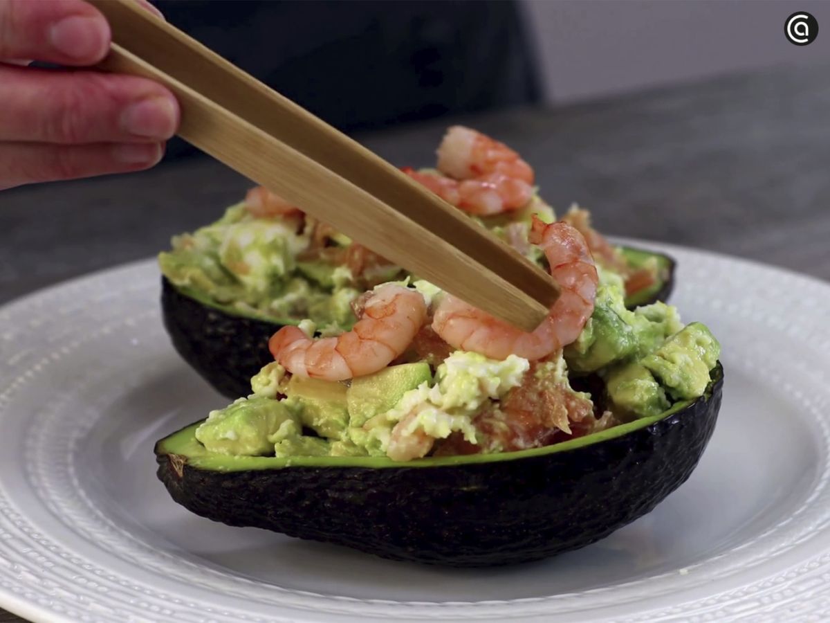 Rellena las cáscaras de los aguacates con la mezcla y decora