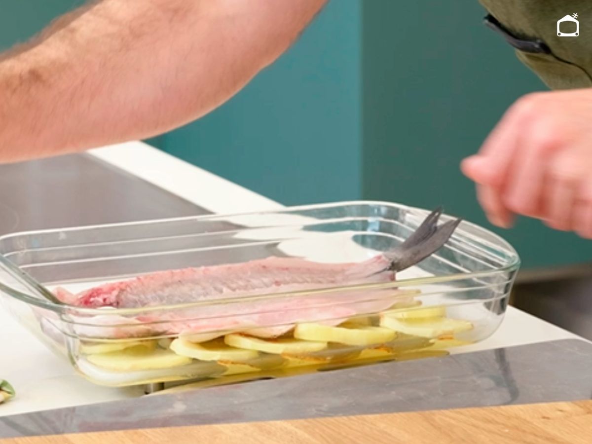 Hornea la lubina sobre las patatas hasta que quede en su punto