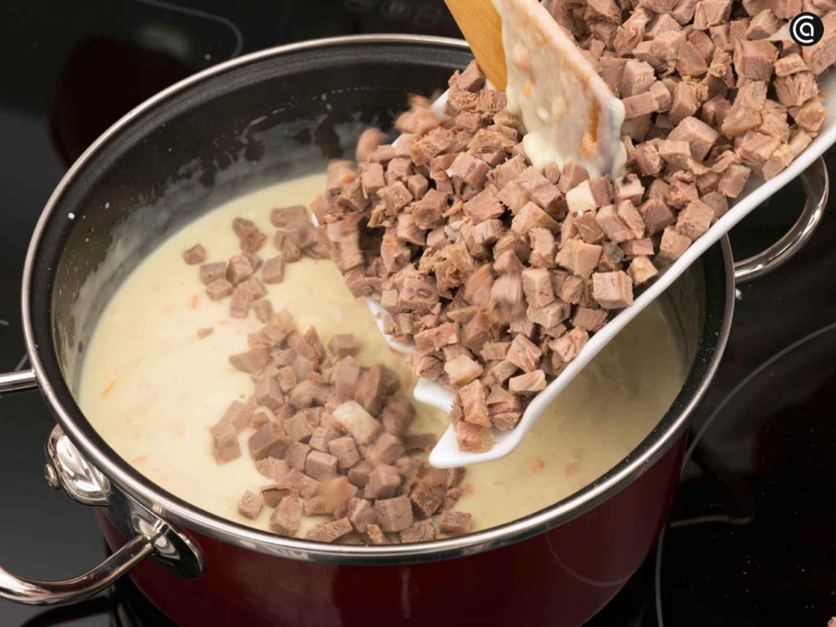 Añade la carne a la bechamel