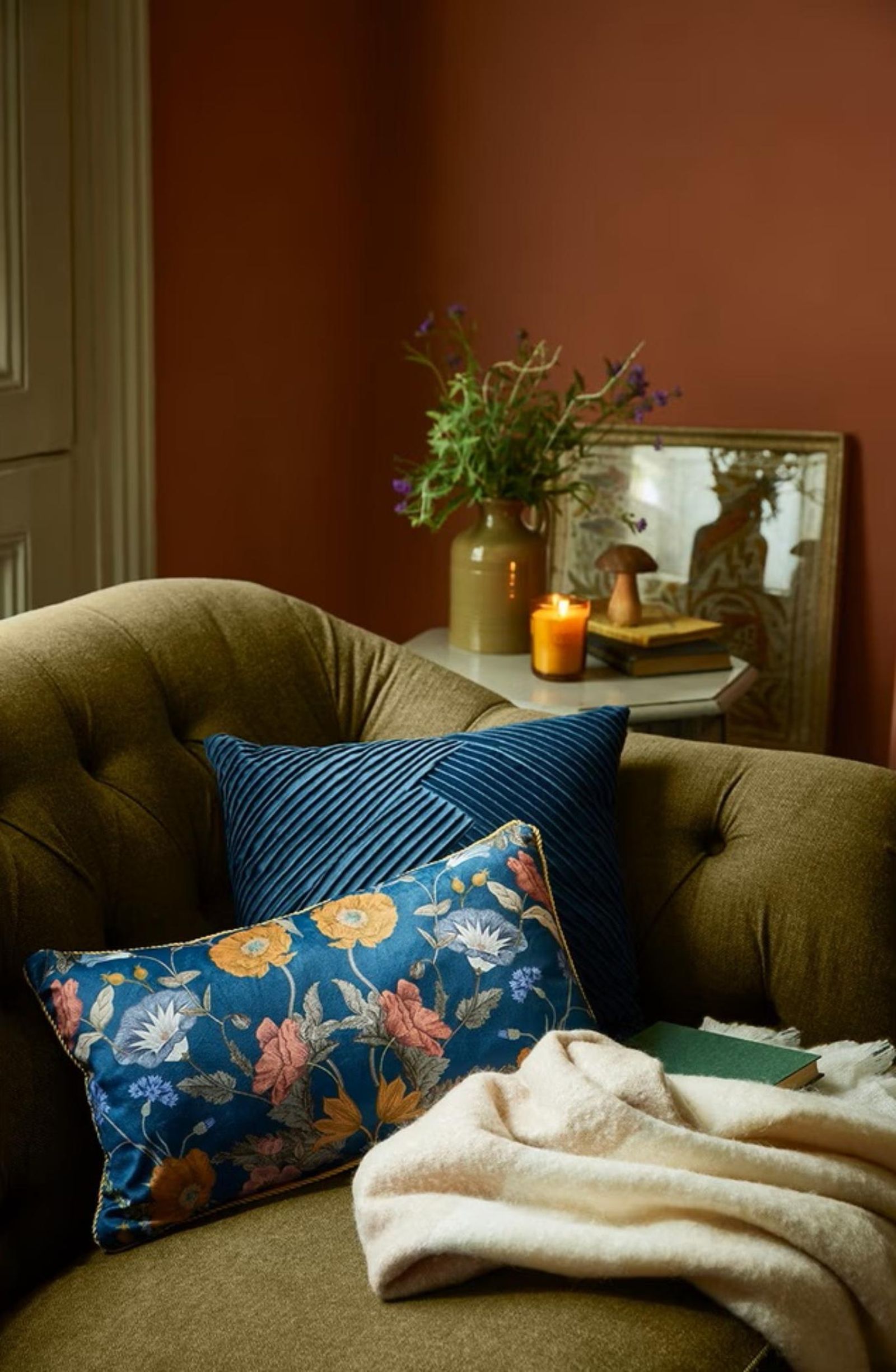 Sofá verde con cojines florales de estilo Cabincore. Sofá verde con cojines florales de estilo Cabincore.