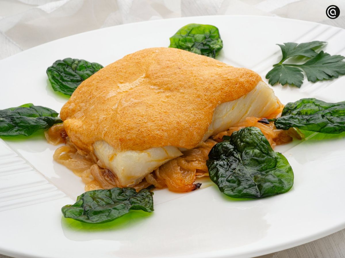 Un bacalao jugoso bajo un gratinado dorado que huele a celebración.