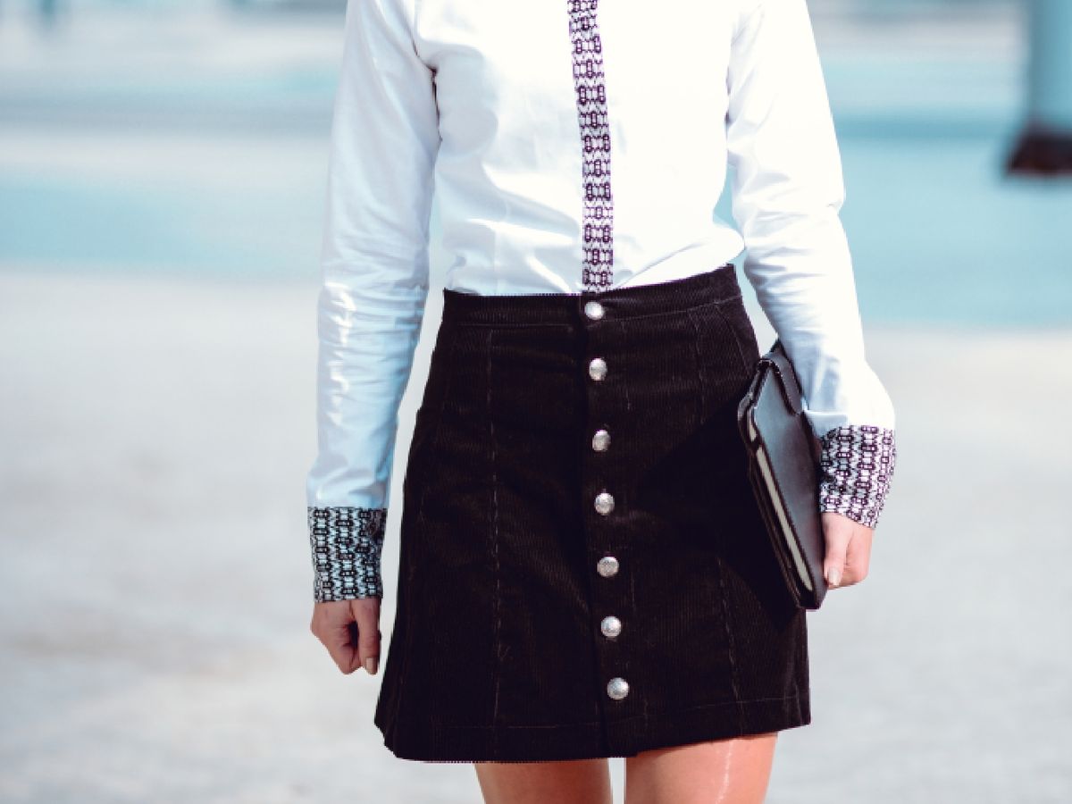La falda con botones frontales alarga visualmente la silueta