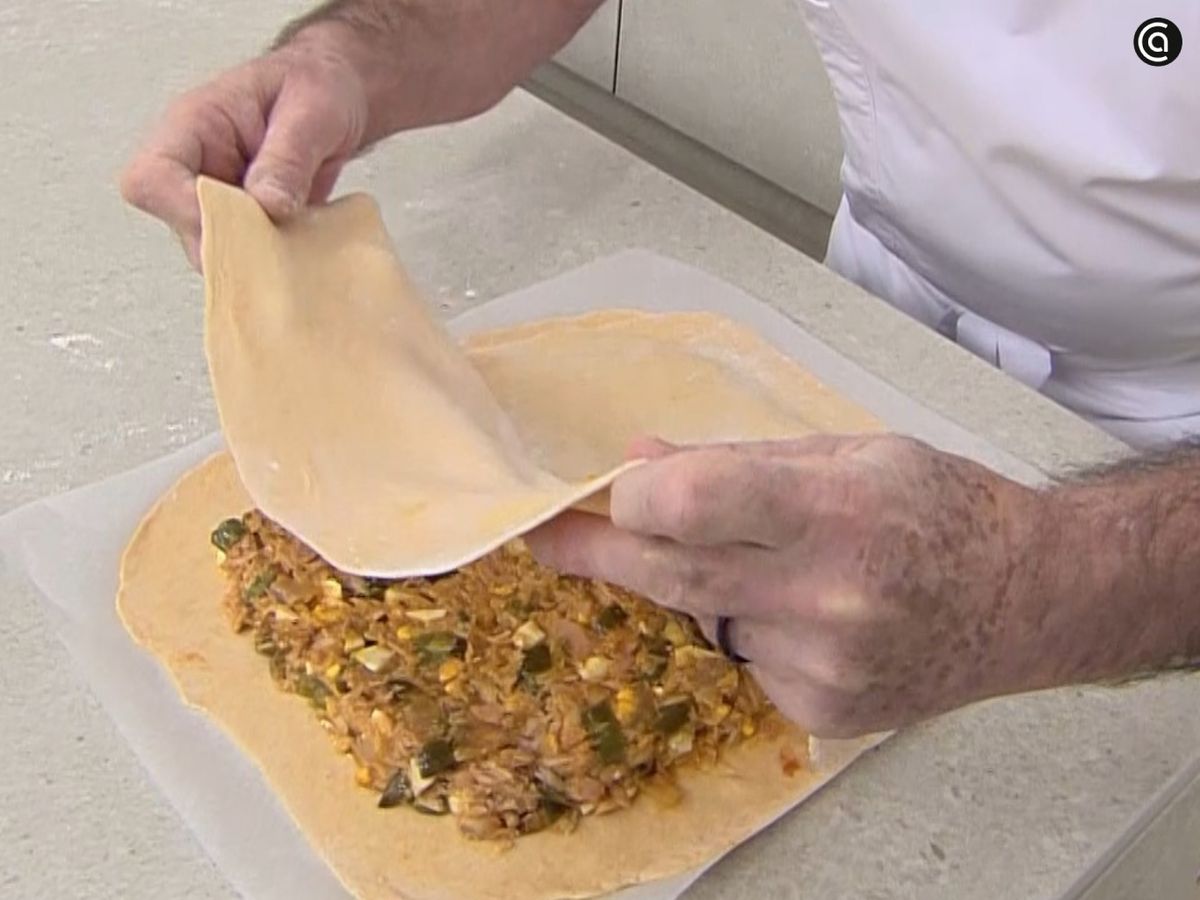 Extiende el relleno sobre la masa y cierra la empanada