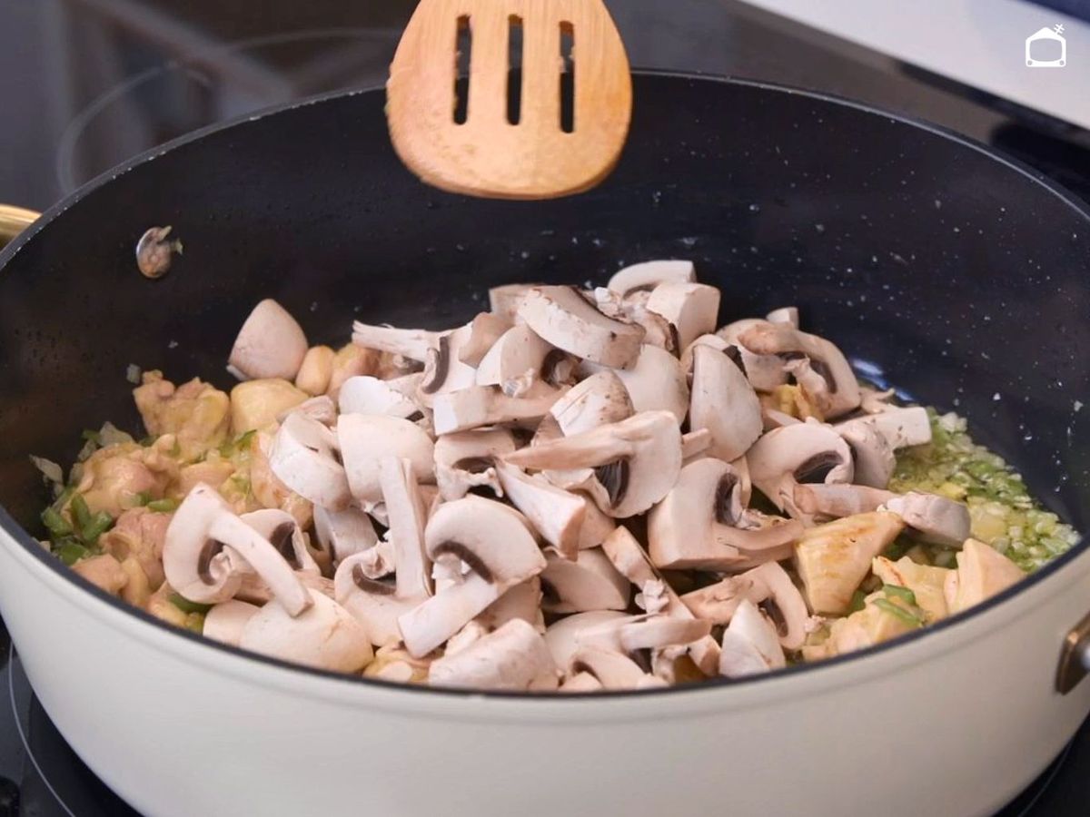 Añadir los champiñones al arroz meloso con pollo