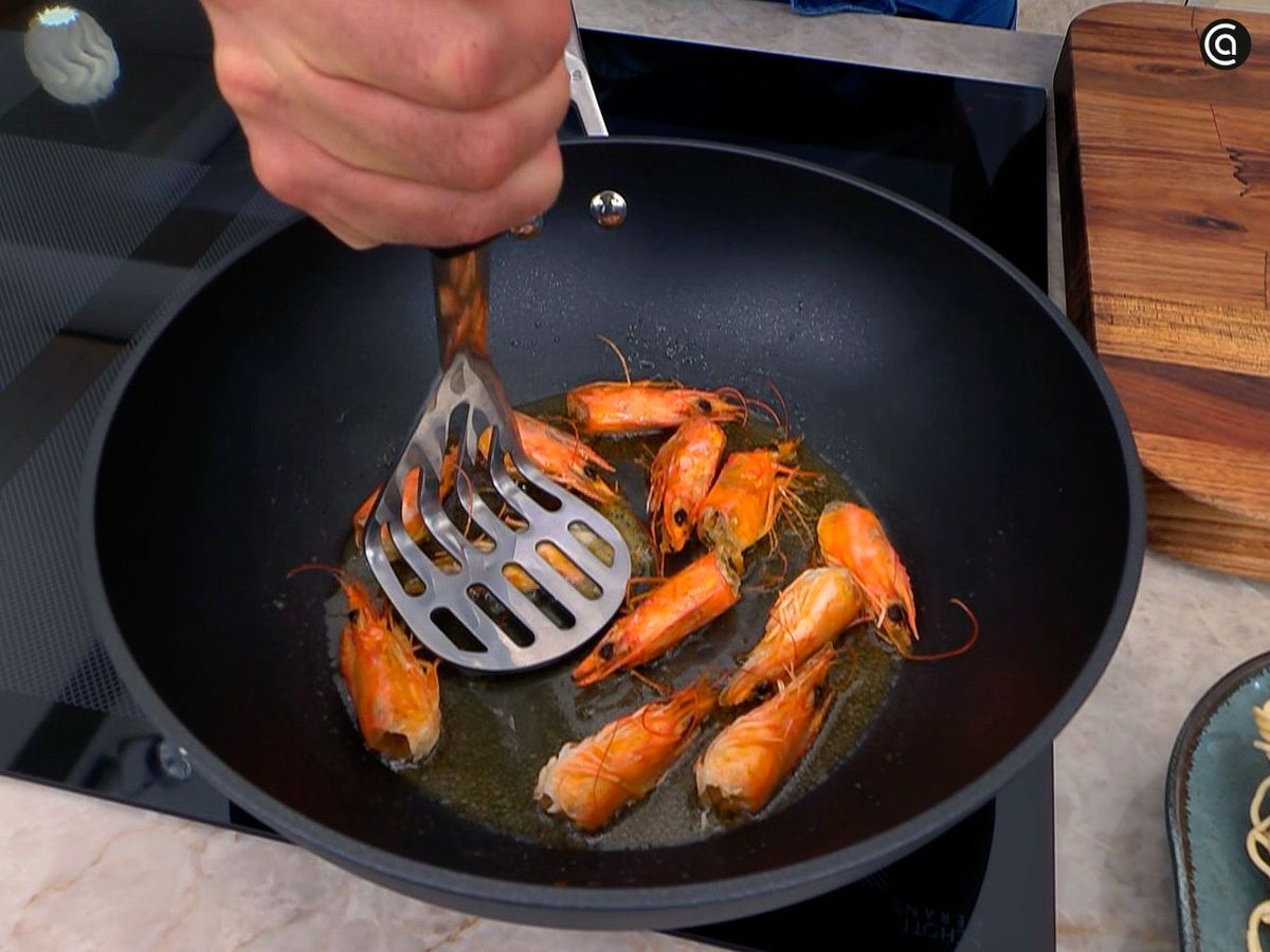 Aplastar las cabezas de los langostinos para dar sabor al pad thai