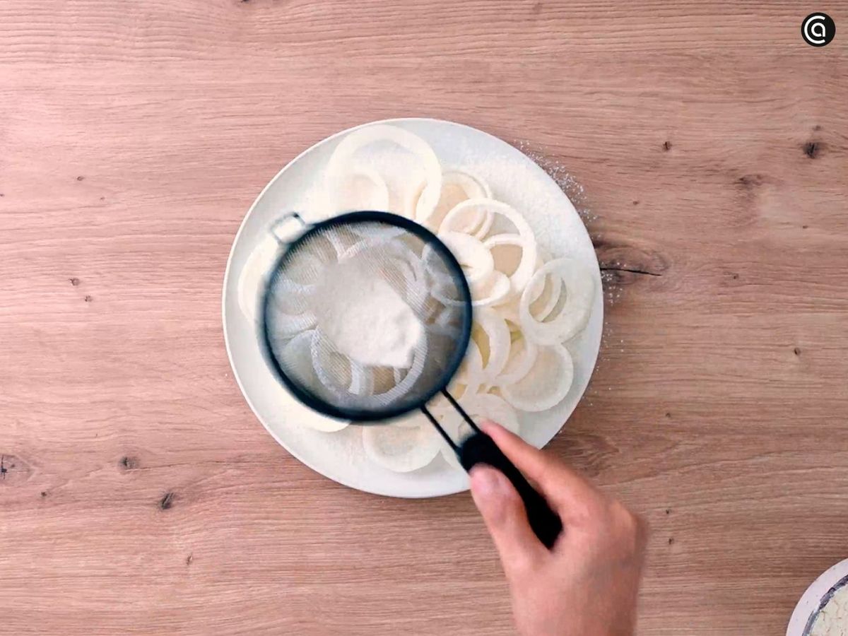 Espolvorea harina sobre los aros de cebolla