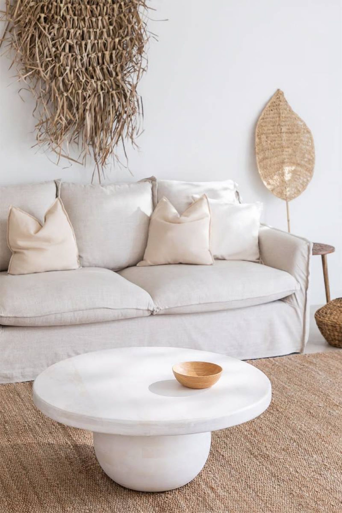 Salón beige moderno con mesa redonda blanca.