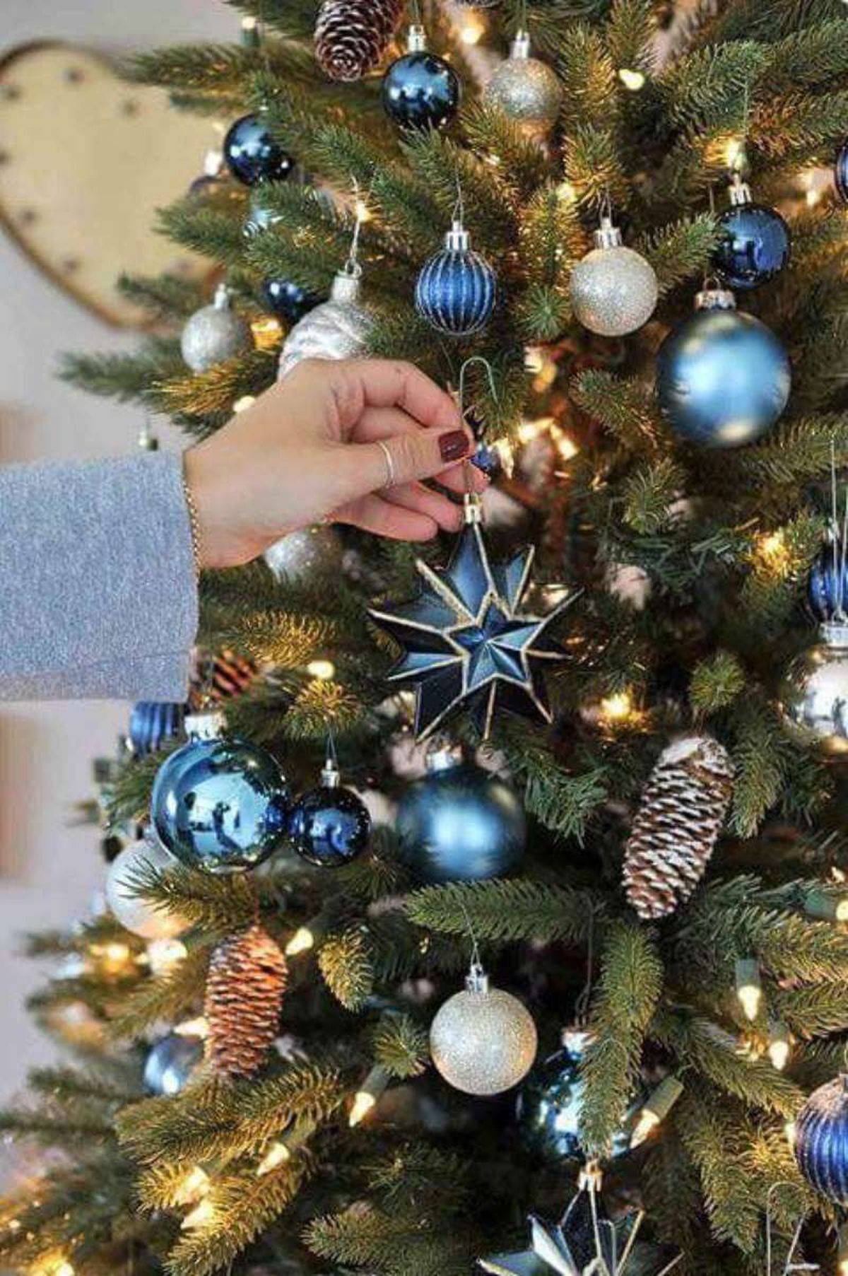 Árbol de Navidad decorado en azul marino y con piñas secas.