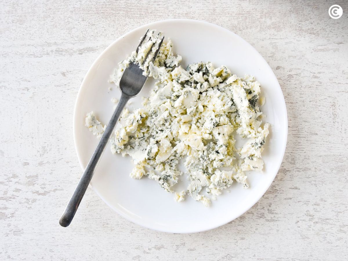 Aplastar el queso roquefort para hacer la salsa de las endivias rellenas