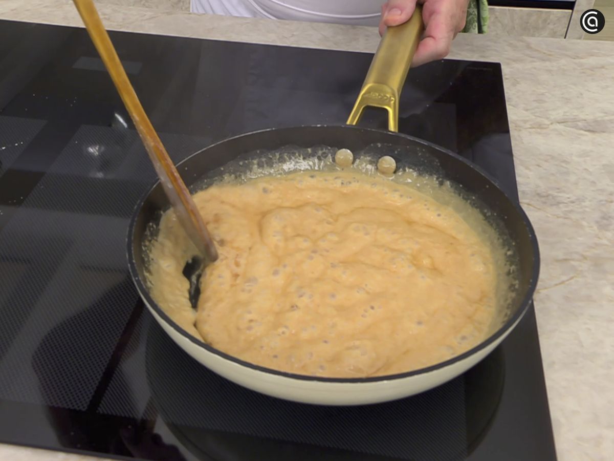 Añade la nata caliente a la sartén con el caramelo de azúcar