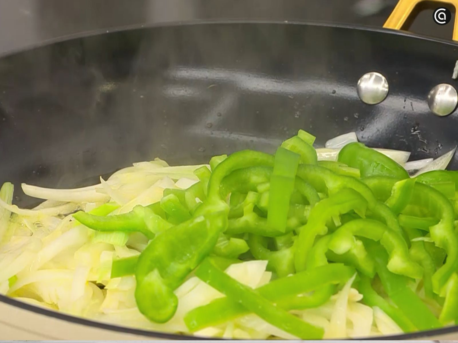 Sofríe la cebolleta y el pimiento verde en juliana.