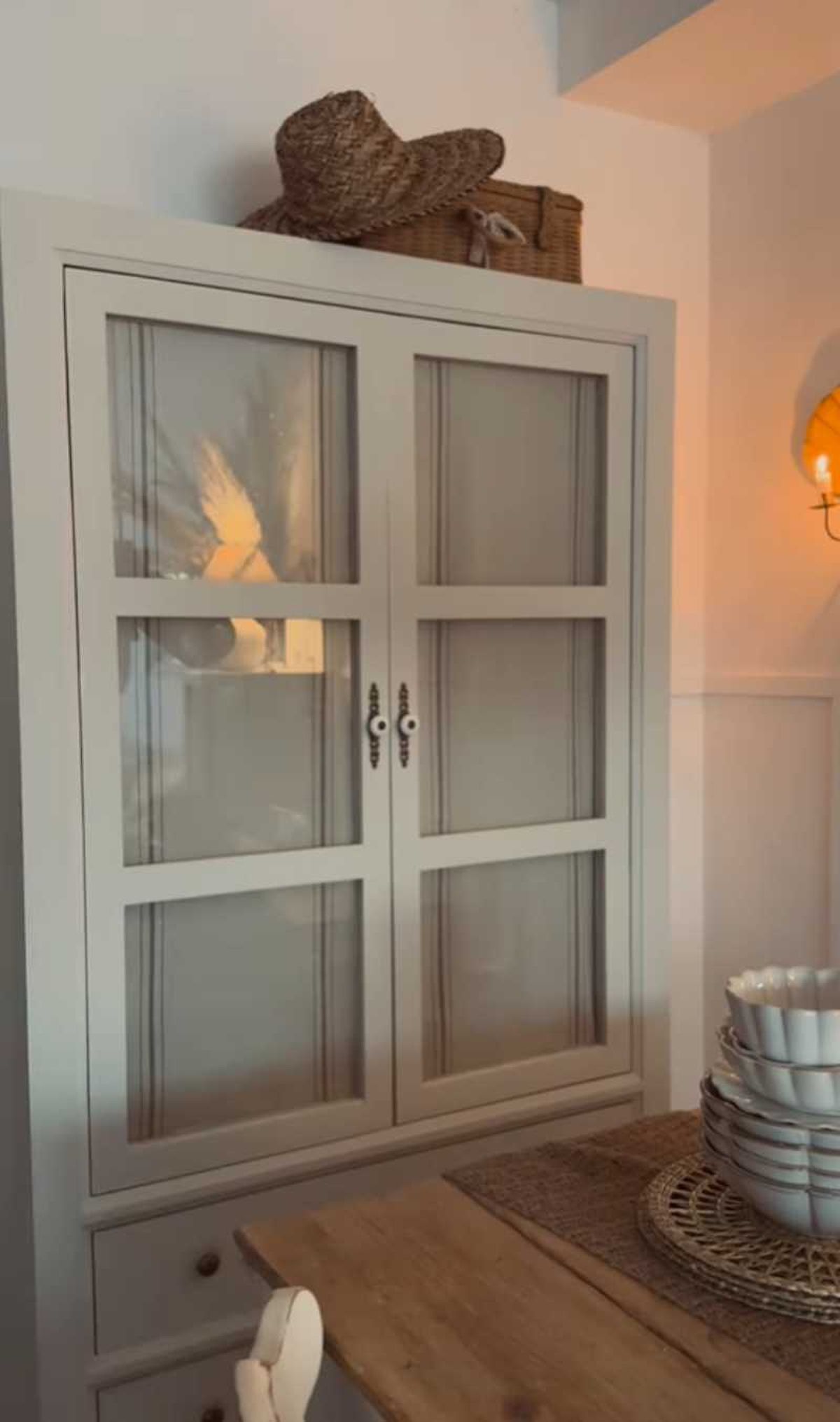 Vitrina con cortinas hechas con caminos de mesa.