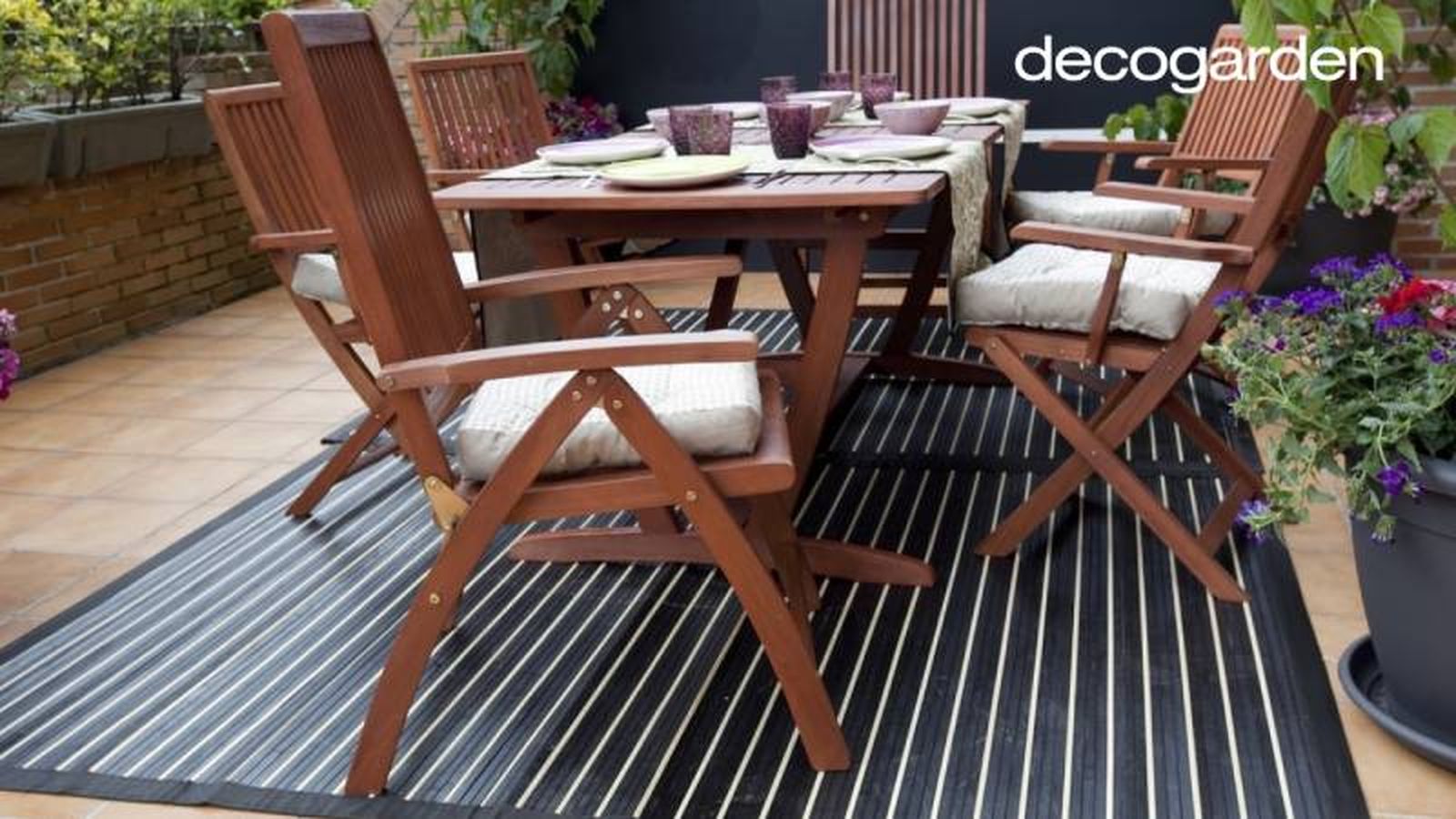 Terraza decorada con mesa y sillas de madera y alfombra vinílica. Terraza decorada con mesa y sillas de madera y alfombra vinílica.