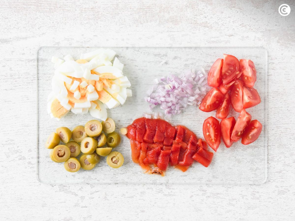 Cortar los ingredientes de la ensalada de pasta con atún