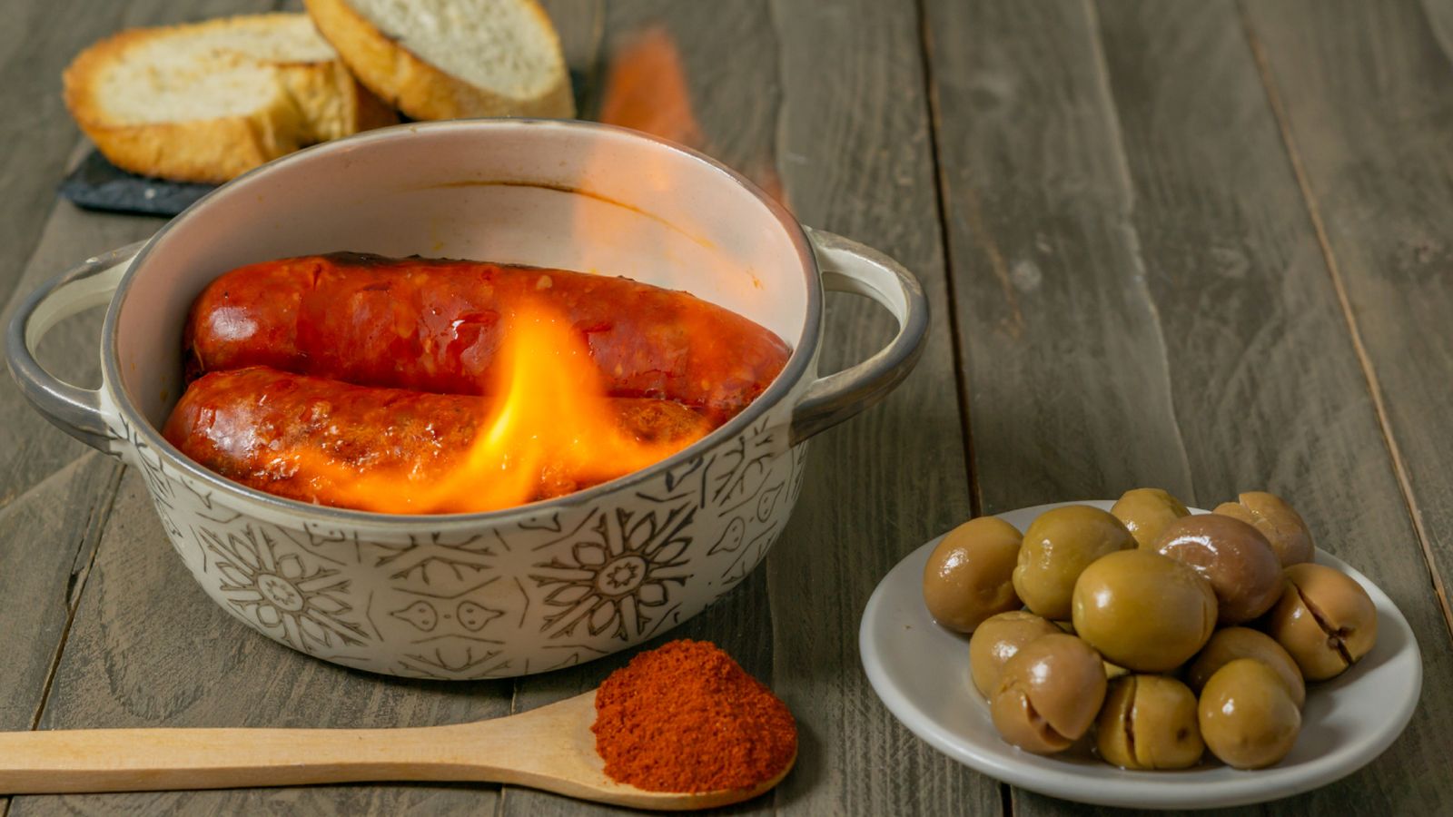 El clásico chorizo al infierno, flambeado con aguardiente en la mesa.
