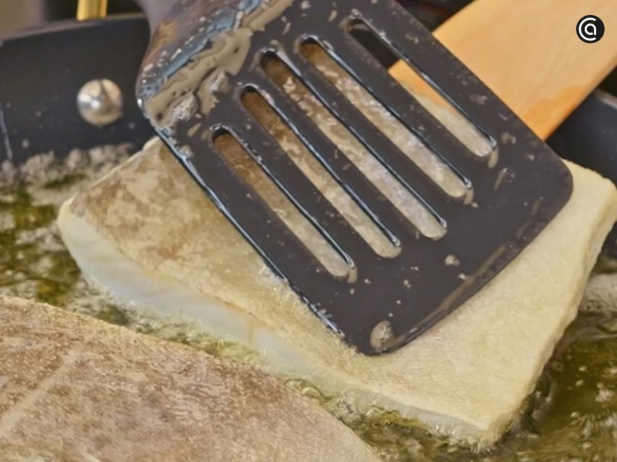 Los trozos de bacalao se colocan en el aceite templado, con la piel hacia arriba, para empezar a confitarlos.