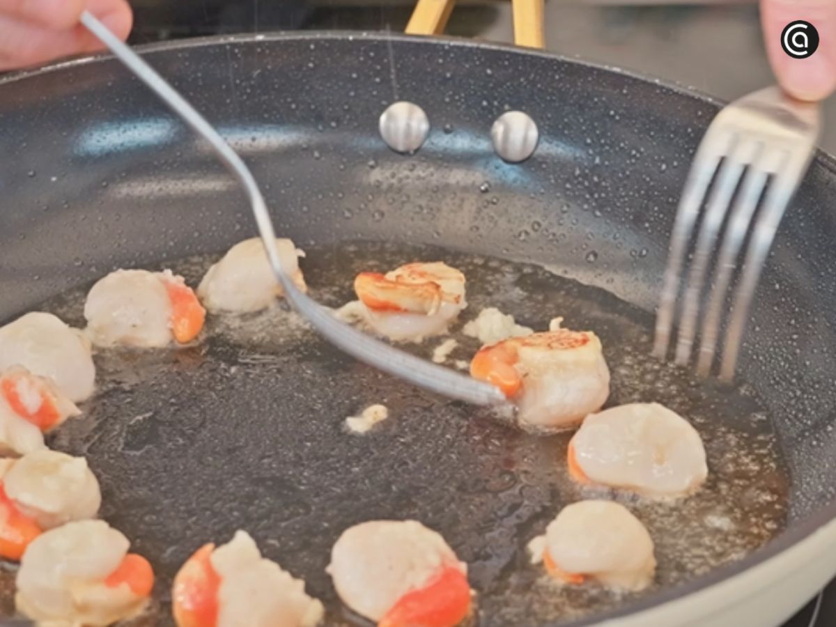 Voltea las zamburiñas con cuidado para que se hagan por ambos lados sin romperse.