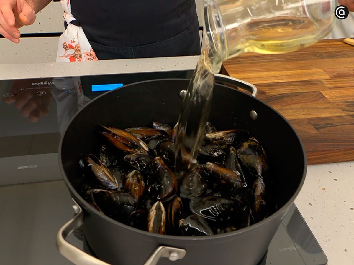 Añade los mejillones y el vino, y cocina hasta que se abran