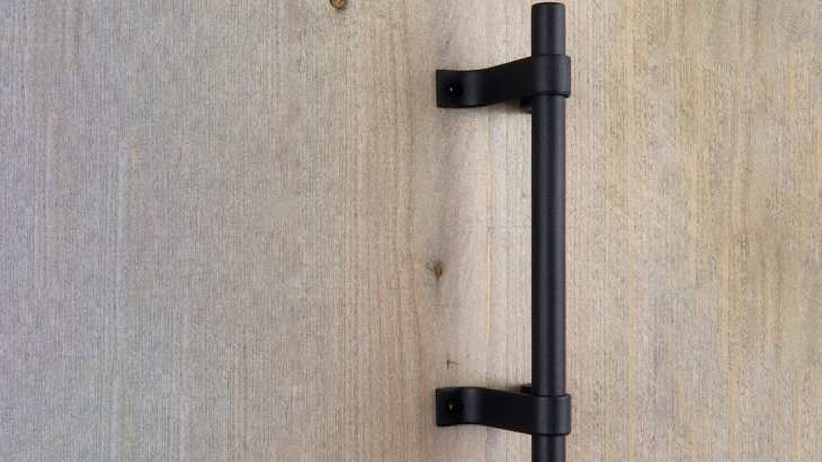 Tirador negro en una puerta de madera Tirador negro en una puerta de madera