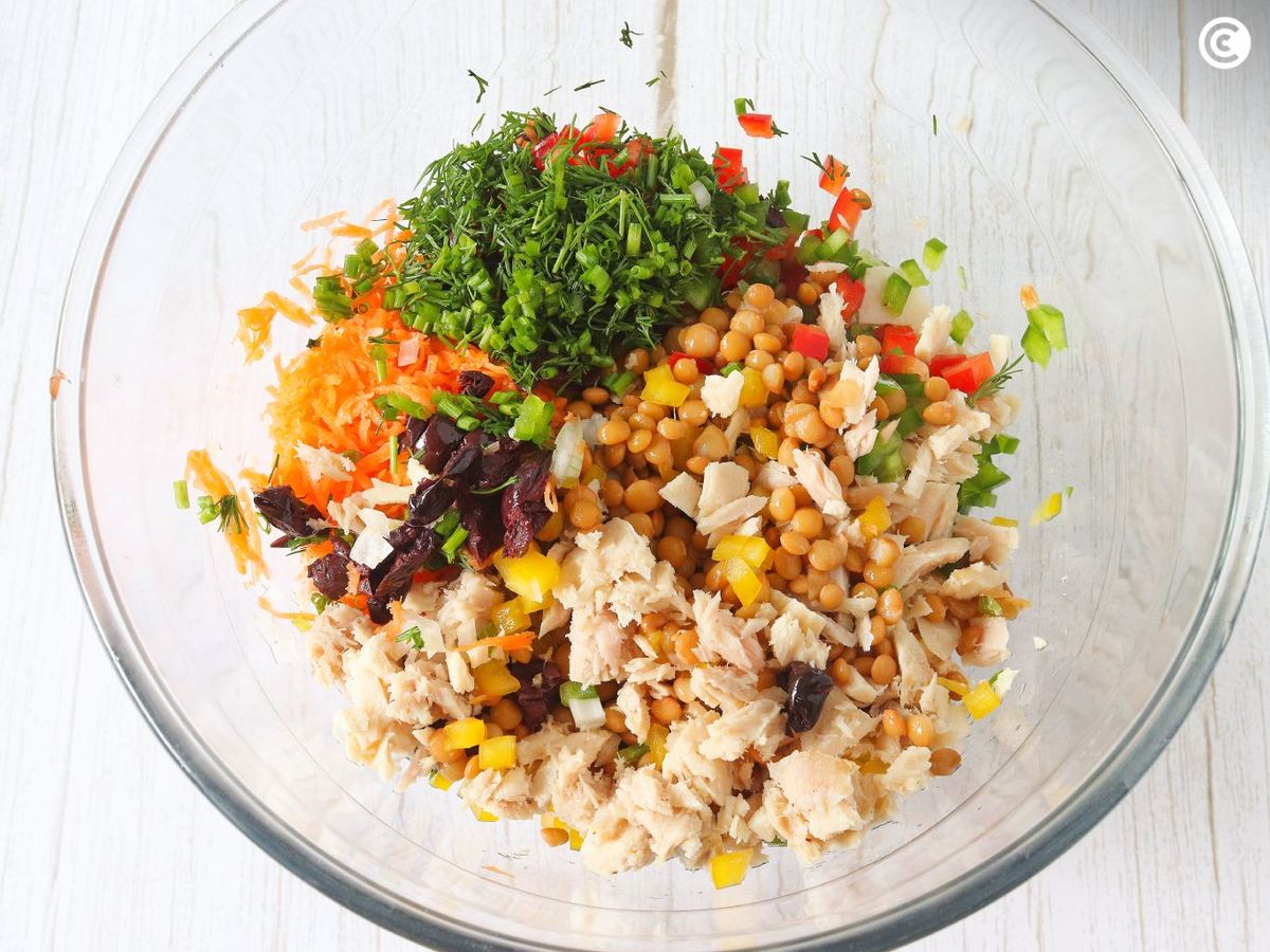 Mezclar los ingredientes de la ensalada de lentejas y atún