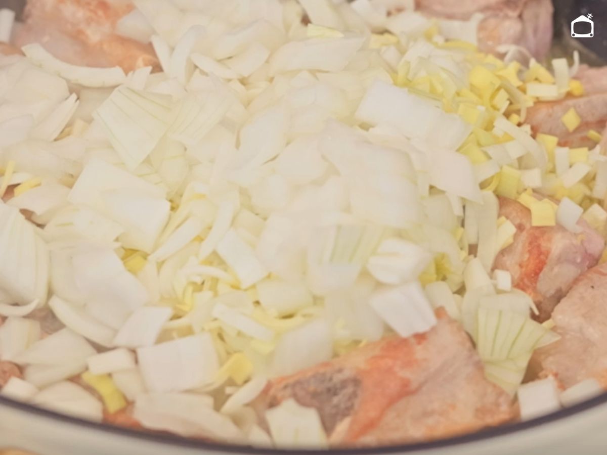 La cebolla y el puerro se van ablandando poco a poco, recogiendo todos los jugos de la carne.