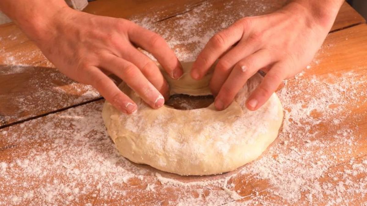 Formar un agujero en el centro de la masa y moldearla en forma de rosco es un paso clave para crear la tradicional forma del roscón de Reyes