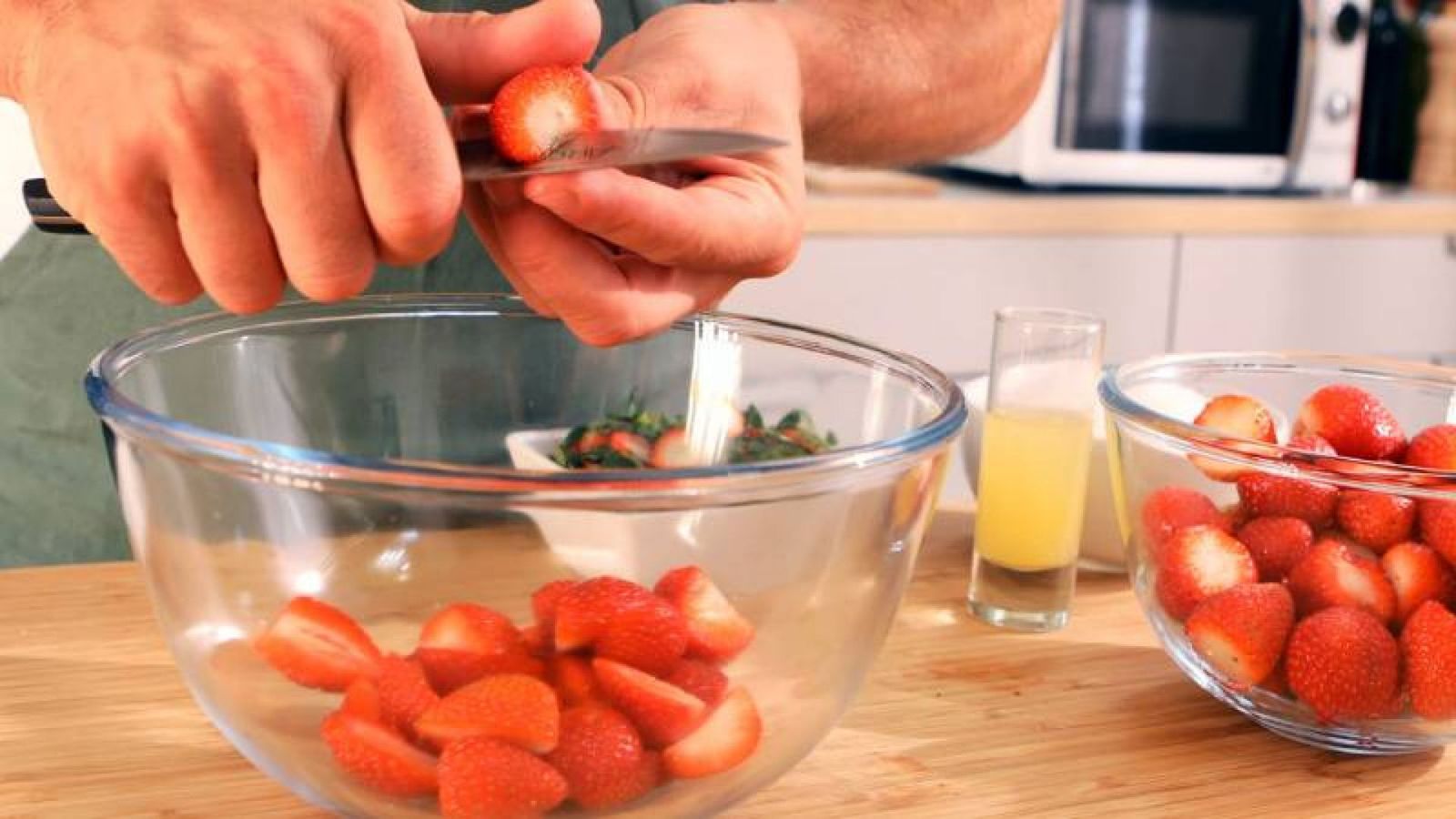Corta las fresas por la mitad Mermelada de fresa Paso 1