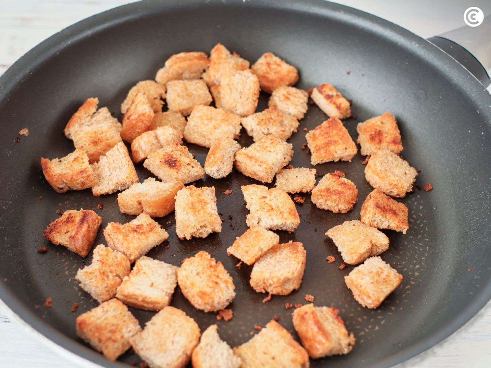 Tostar el pan para hacer picatostes para la sopa de almendras veganas