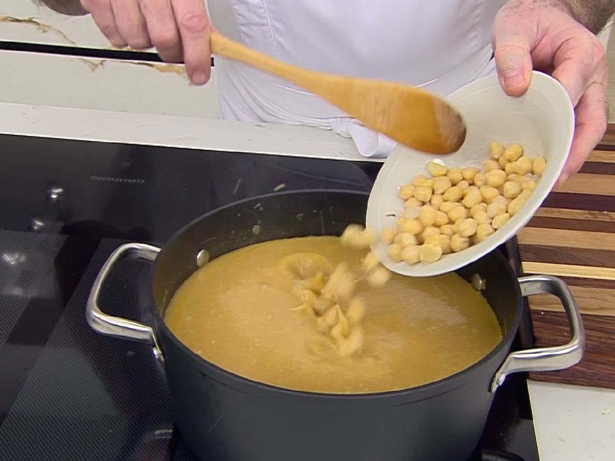 Añade el pescado y los garbanzos a la sopa de pescado con garbanzos y cuece solo un minuto