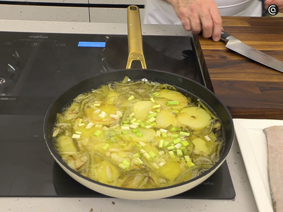 En una sartén, fríe las patatas con la cebolleta y los ajos tiernos