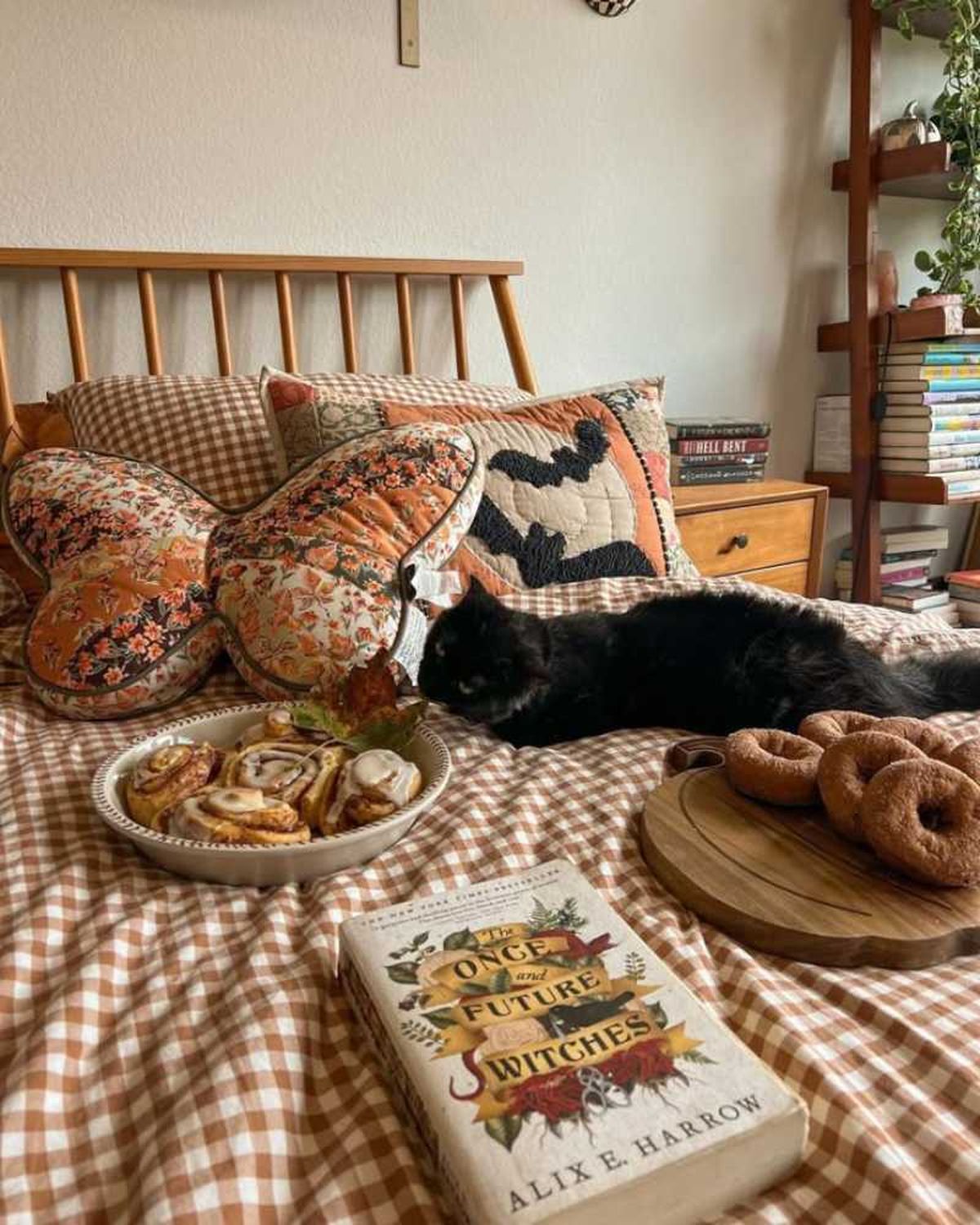 Dormitorio con detalles witchy con un gato negro en la cama.