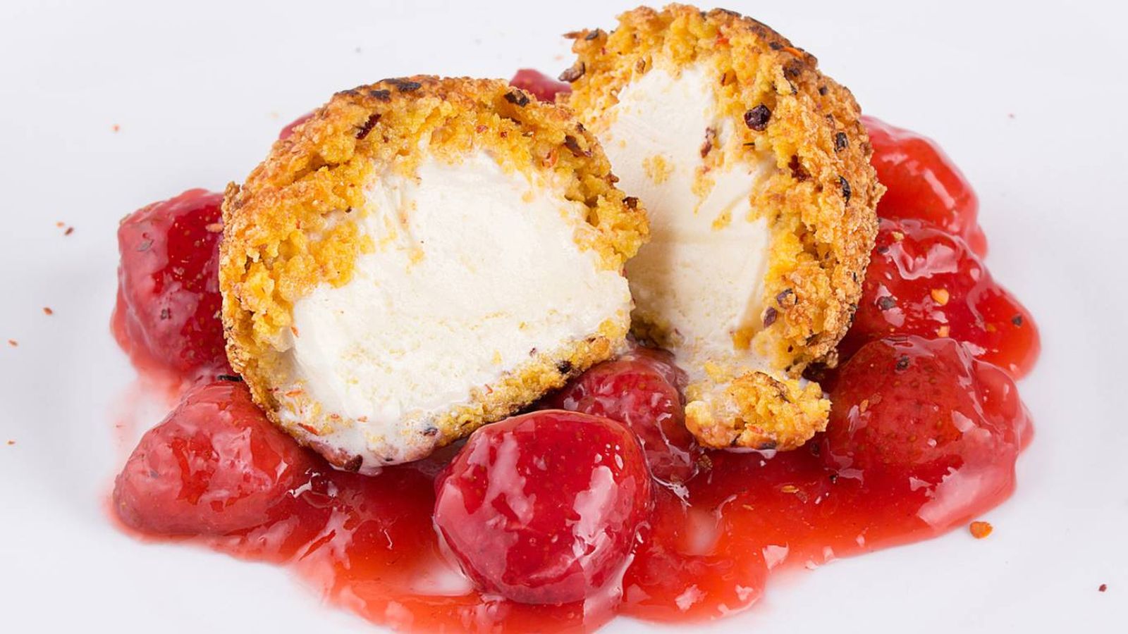 Helado frito en airfryer servido con fresas confitadas: crujiente por fuera, cremoso por dentro.