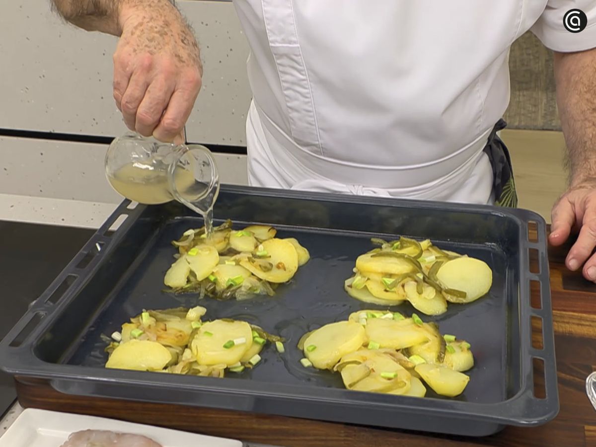 Vierte el caldo por encima de las patatas panadera y hornea