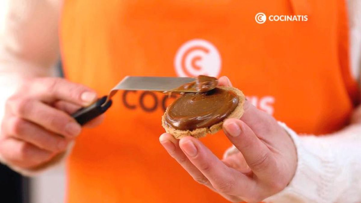 Unta las galletas con el dulce de leche y reboza el borde con el coco rallado