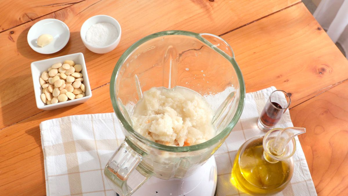Agrega la miga de pan remojada al vaso de la batidora para iniciar la preparación del ajoblanco