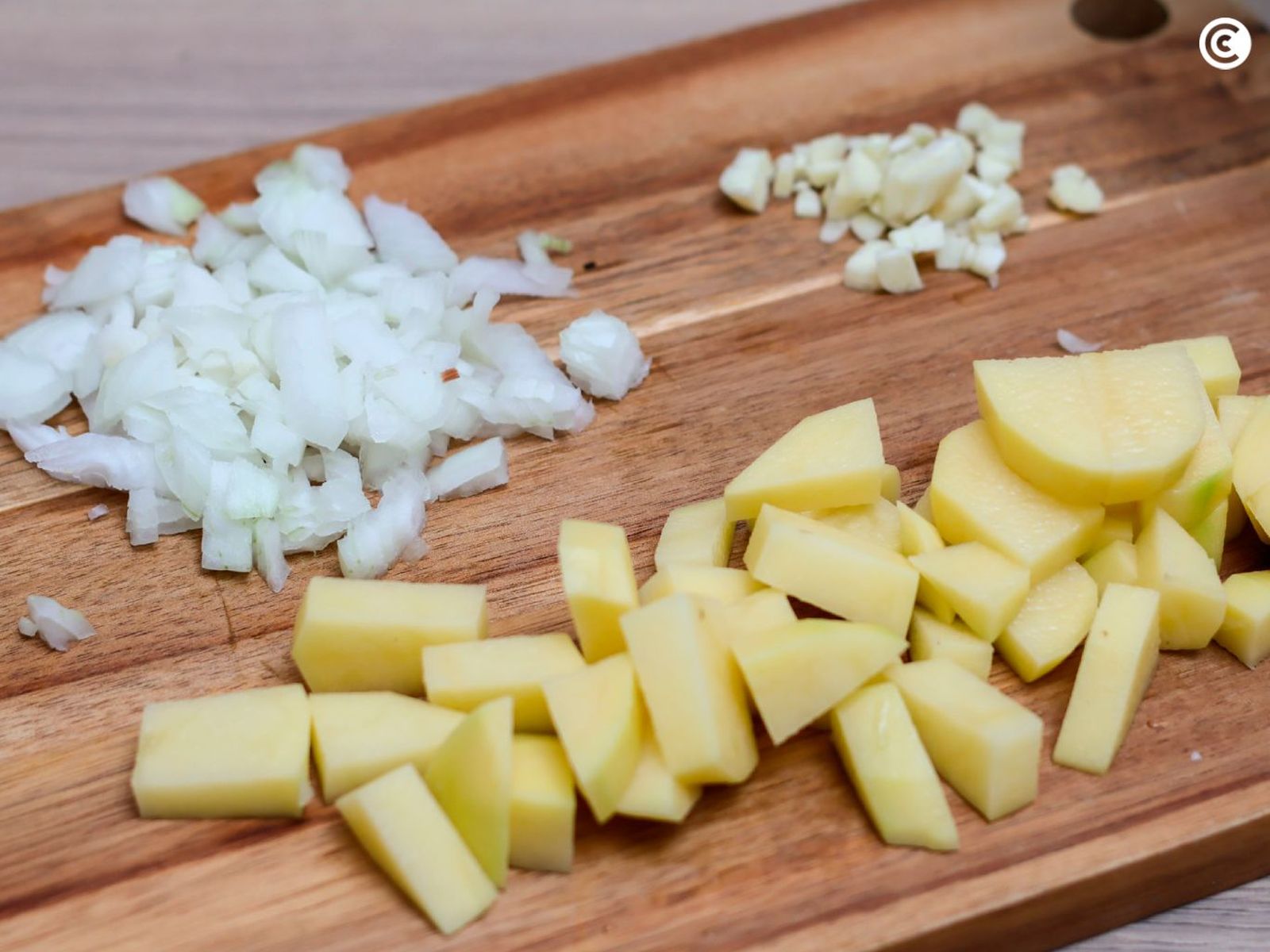 Cortar las patata, cebolla y ajo para la crema de espárragos verdes