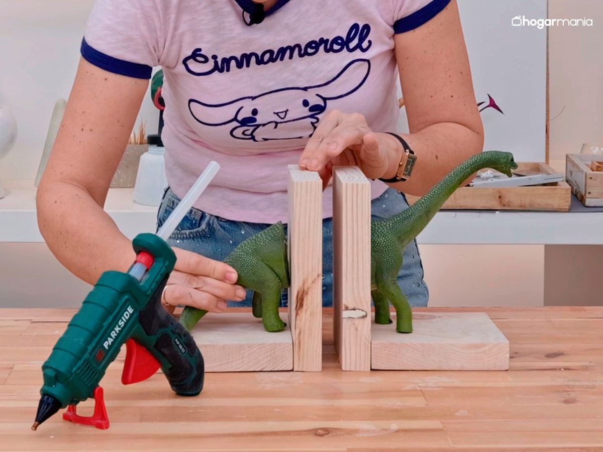 Fija el dinosaurio a la base del sujetalibros