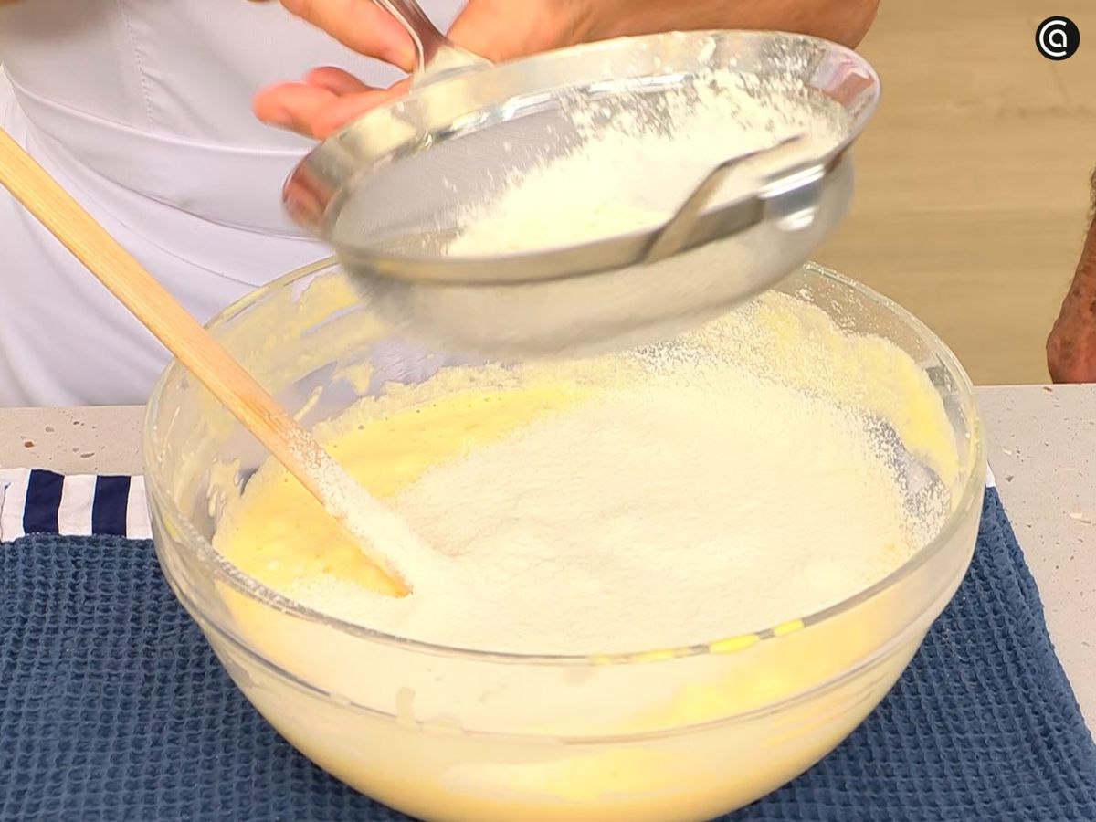 Agrega la harina tamizada poco a poco y mezcla suavemente