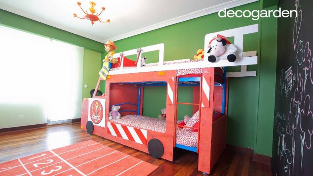 Dormitorio infantil con cama de camión de bomberos y pared de pizarra.