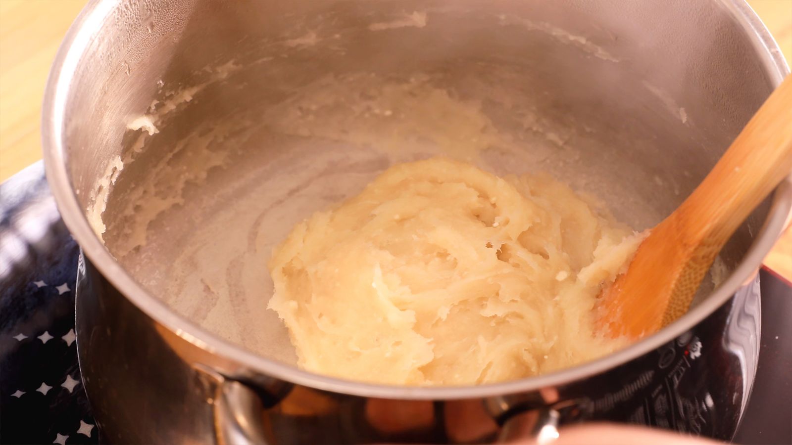 Combina agua, mantequilla, azúcar y sal en una cazuela para crear la base de tus profiteroles