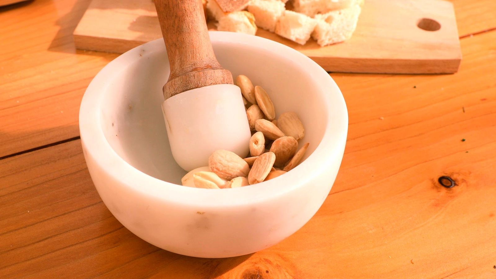 Machaca los ajos, las almendras y el pan Receta de caldereta de cordero con patatas paso 1