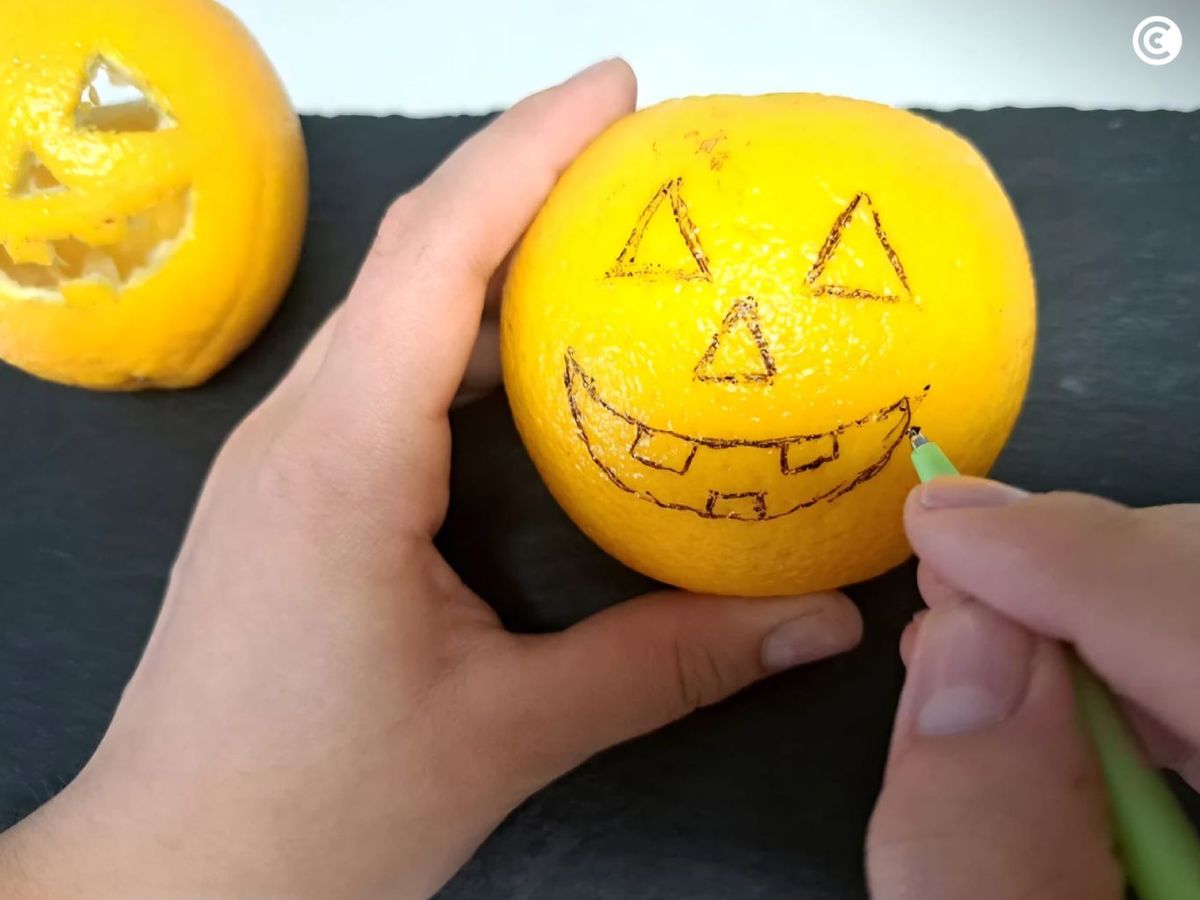 Decorar la piel de naranja como una calabaza de Halloween para rellenar de mousse de naranja y chocolate