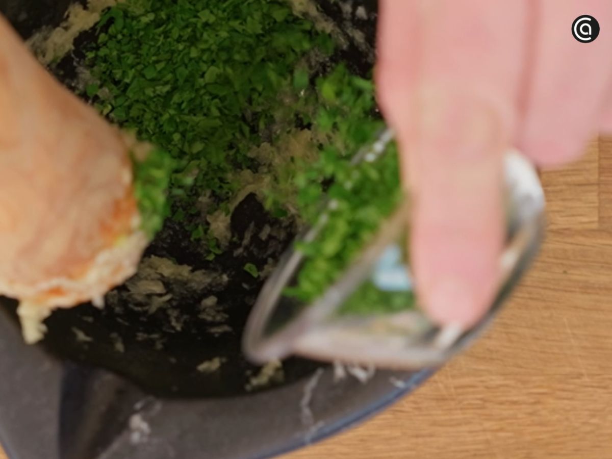 El ajo y el perejil se machacan en el mortero para potenciar el aroma.