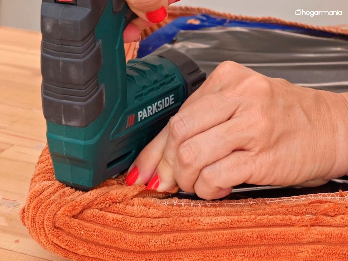 Tapiza la silla grapando la tela a la base