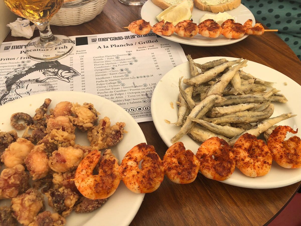 Raciones de pescaíto frito y marisco a la plancha, una delicia típica cocinada al momento en el Mercado Atarazanas.