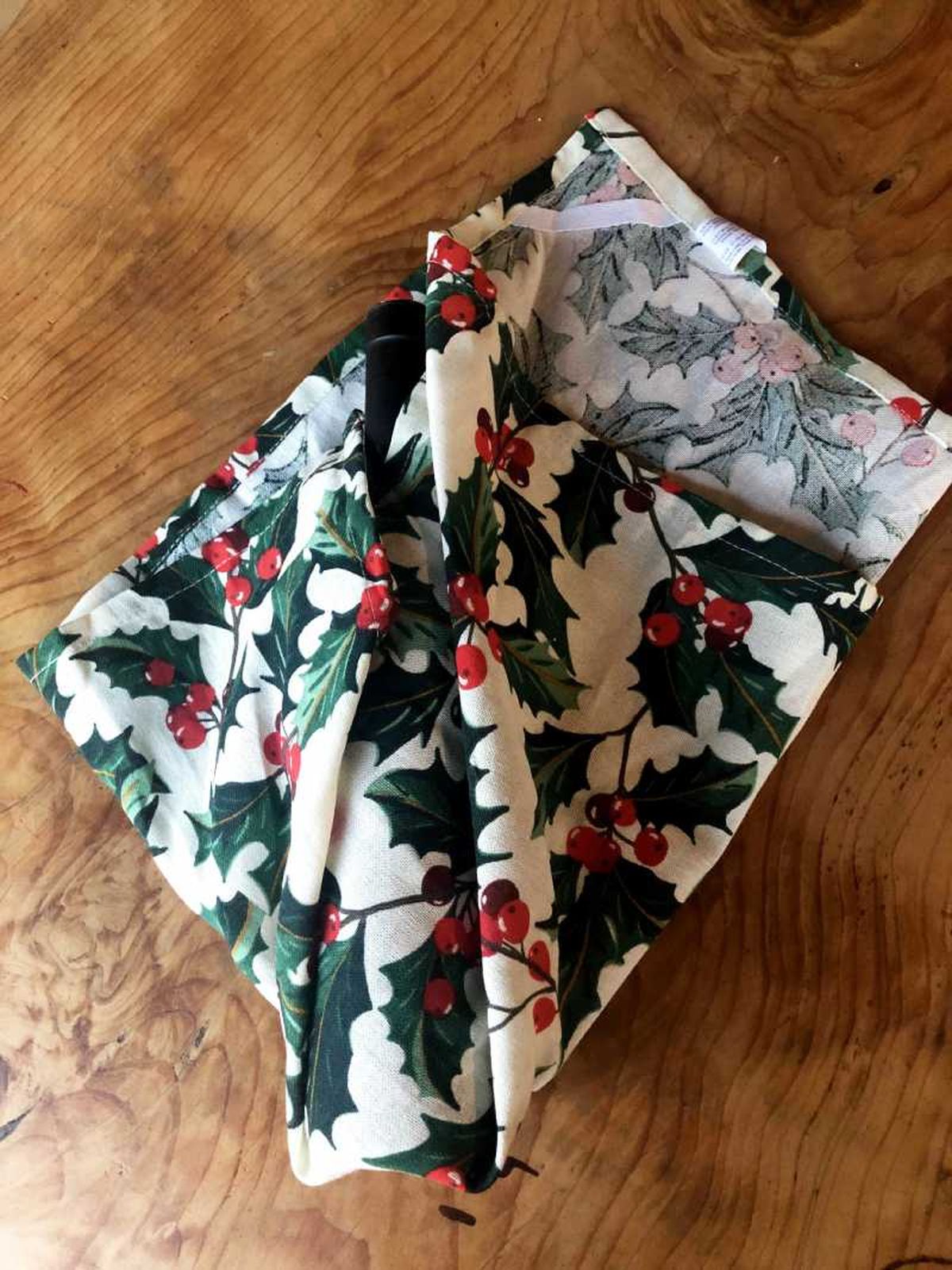 Paso dos para envolver una botella en tela furoshiki.