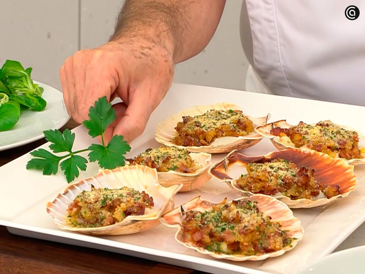 Sirve las vieiras a la gallega con una guarnición de canónigos